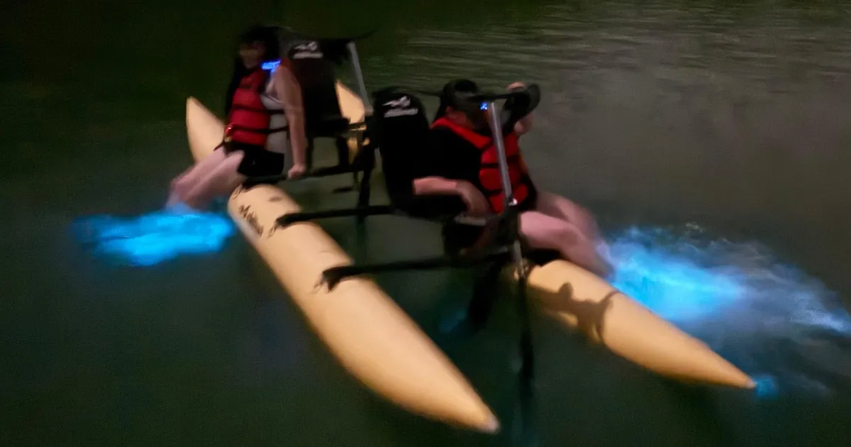 Water bike rider over glowing blue water at night on a La Parguera bioluminescent bay water bike tour in Puerto Rico
